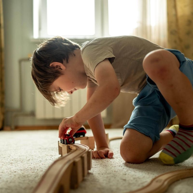 Kind spielt auf dem Teppichboden
